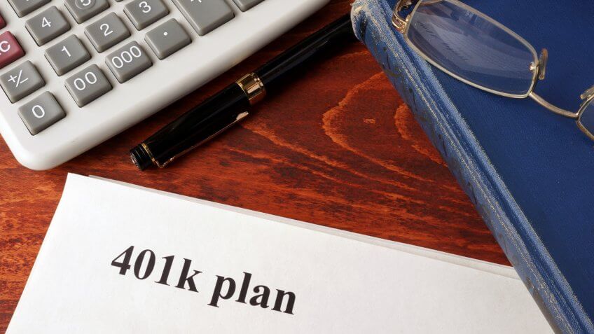 Papers with 401k plan and book on a table.