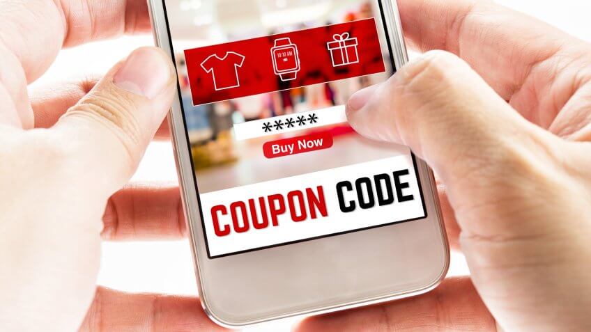 Close up Two hand holding mobile phone with coupon code word and blurred store background, Digital Marketing concept.