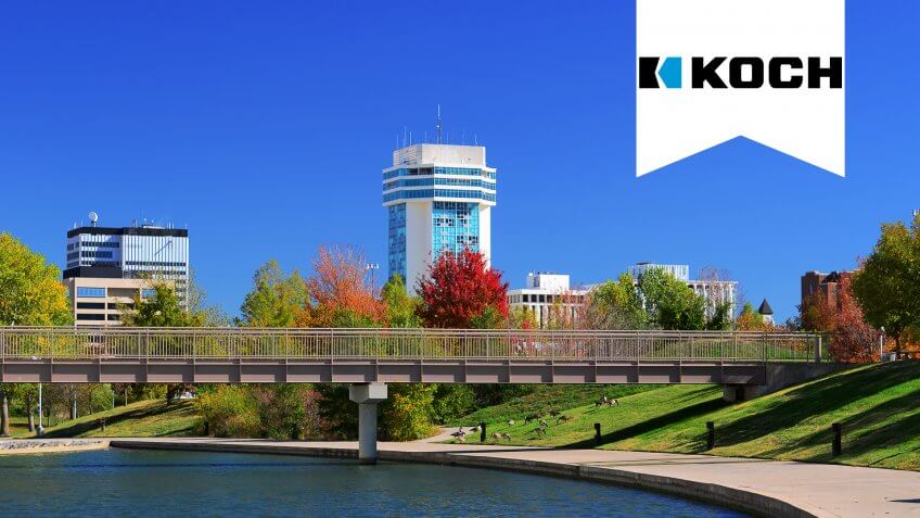 Downtown Wichita skyline with a waterway and park in the foreground.