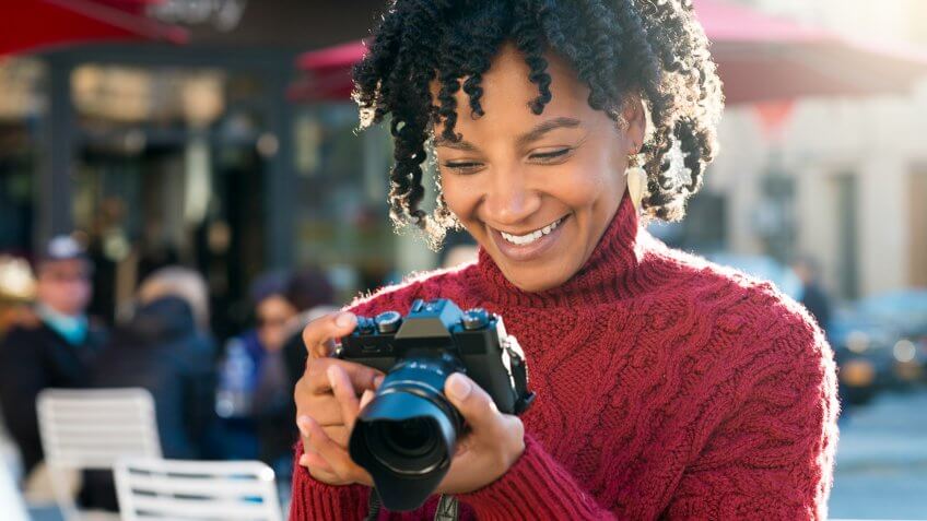 Portrait of tourist with digital camera at cafe.