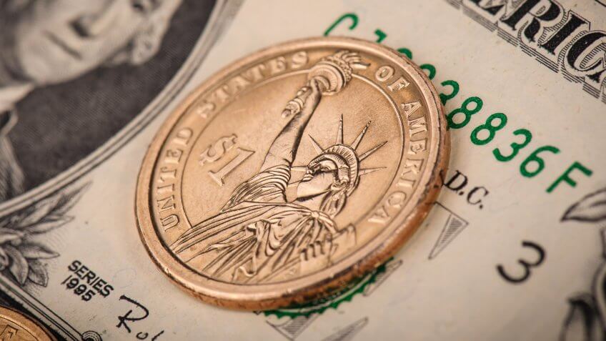 close up of US dollar bill and US dollar coin
