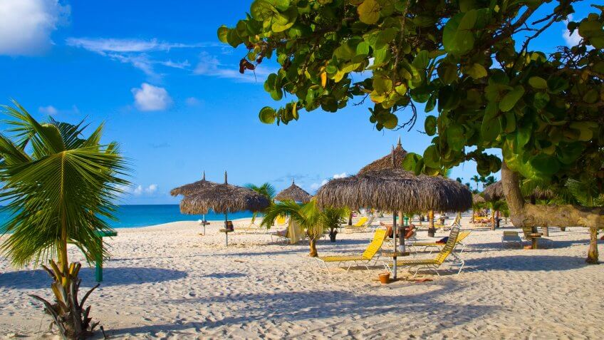 Beautiful beach with palapas and palmtrees, Eagle Beach, Aruba.