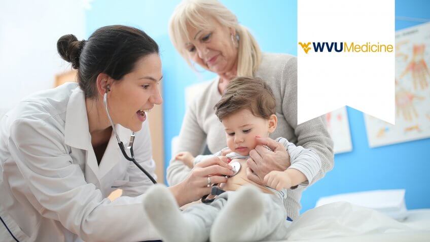 Female doctor with stethoscope listening to the baby patient.