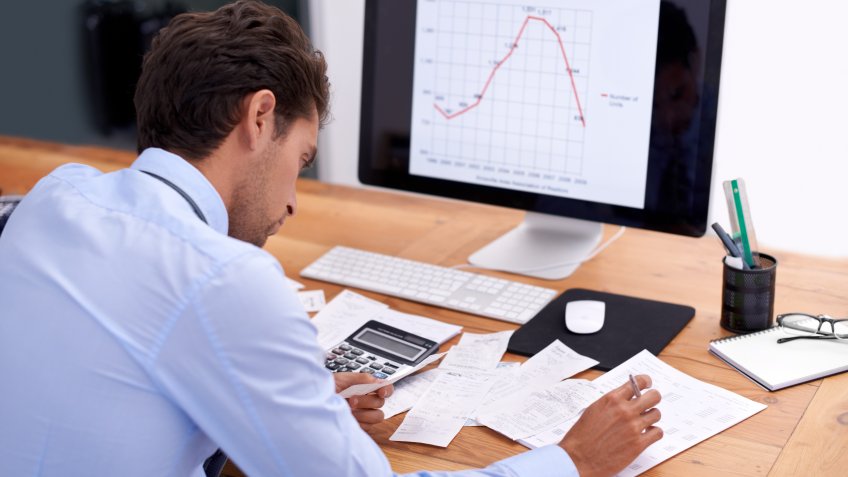 Rearview shot of a handsome young businessman working at his desk.