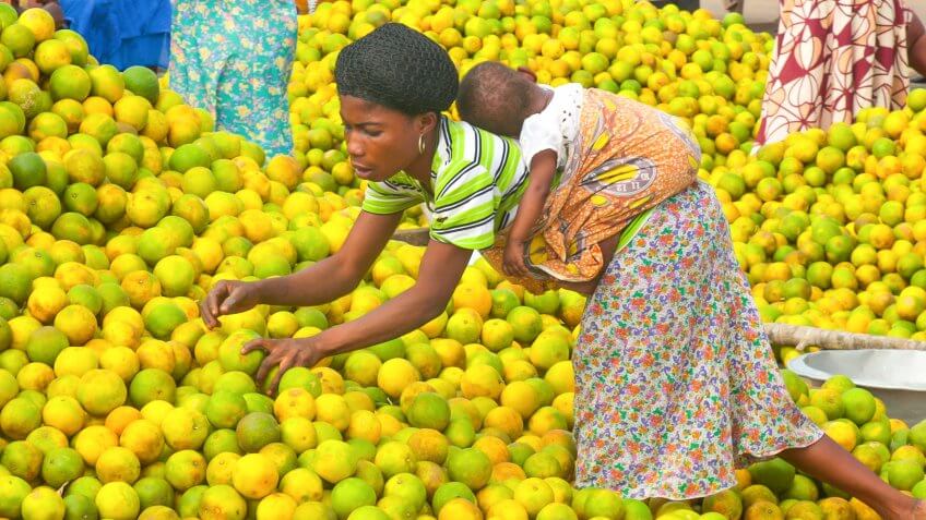 Esiam, Ghana - July 26, 2010: People picking oranges at the market in a small city Esiam near to the border between Ghana and Ivory Coast.
