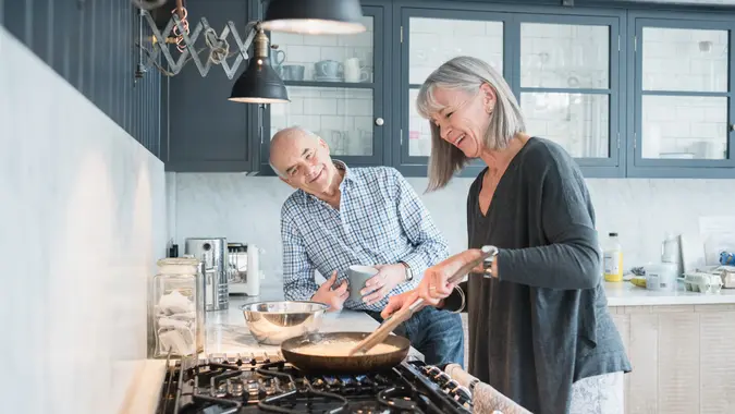 Senior couple making a meal at home in the kitchen.