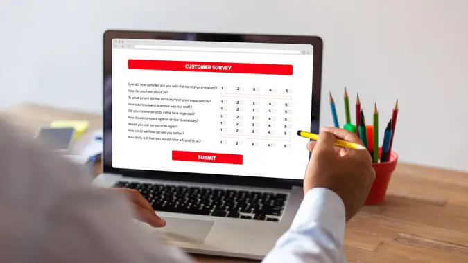 Businessman Filling Survey Form Online on Computer