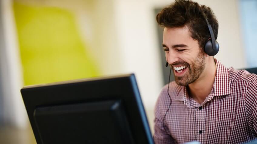 Shot of a friendly young call centre agent sitting at his deskhttp://195.