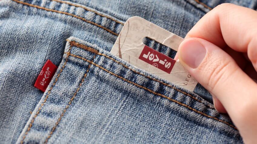 "Tambov, Russian Federation - October 21, 2012 Woman's hand taking out label logo from pocket of a pair Levi's Jeans.