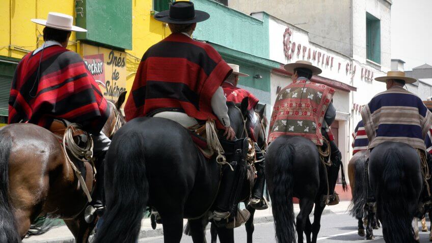 Santiago, Chile - December, 6th 2004: Gaucho's cowboys in traditional ponchos ride through the streets of the Chilean capital as part of a street fiesta.
