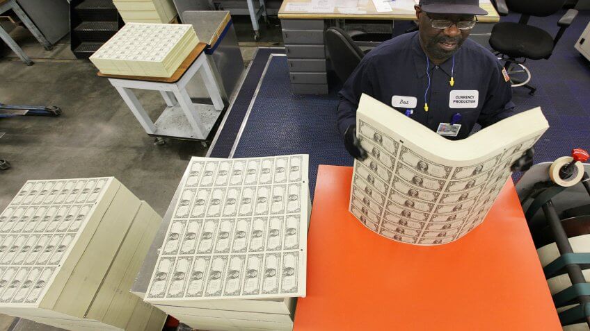 WASHINGTON - MARCH 26: Jefferson Best loosens a stack of one dollar bills on a vibrating table before they are cut into singles at the Bureau of Engraving and Printing on March 26, 2009 in Washington, DC.