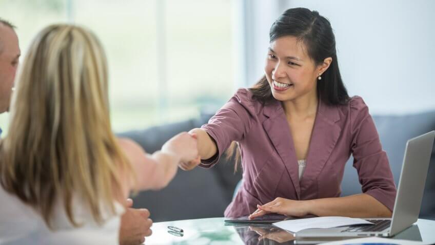 A financial planner is speaking to a husband and wife about their finances, loans, and budget.