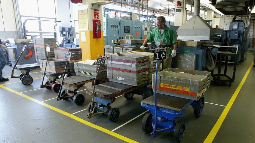 SAN FRANCISCO - MARCH 23: A worker stands behind a cart with coin blanks at the U.