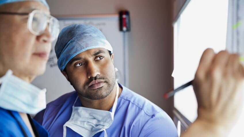 Surgeons analyzing report together in clinic.