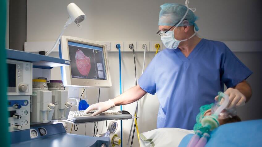 Anesthetist with patient , the patient is the one lying down , and the anaesthetist is the one standing up .