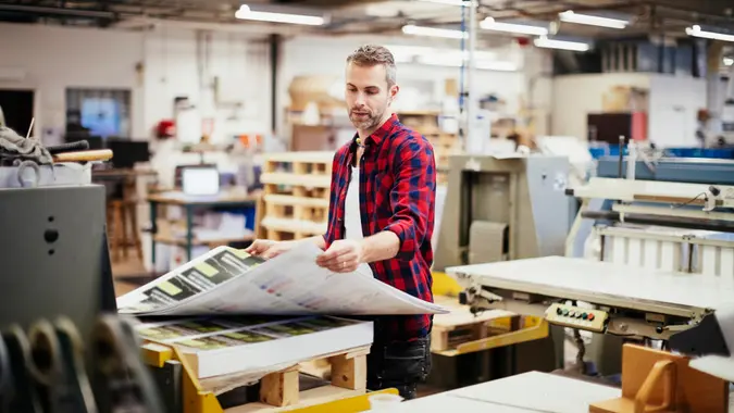 Photo of a man working  in printing factory.