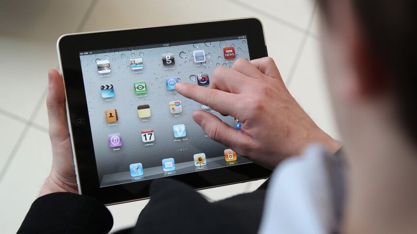 LONDON, ENGLAND - FEBRUARY 17: In this photo illustration, a man uses an Apple ipad tablet on February 17, 2011 in London, England.