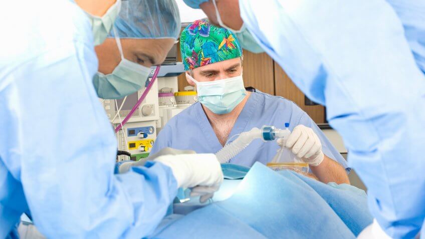 50-54 years, Caucasian, Color Image, Indoors, People, Woman, african ethnicity, anesthesia, anesthesiologist, assisting, california, co-worker, concentration, doctor, five people, healthcare, horizontal, hospital, latin american and hispanic ethnicity, man, mature adult, mature men, mature women, medical, medicine, multi-ethnic group, nurse, occupation, operating room, operation, patient, photography, san diego, scrubs, skill, standing, sterile, surgeon, surgery, surgical cap, surgical mask, teamwork, united states, working, 40-44 Years