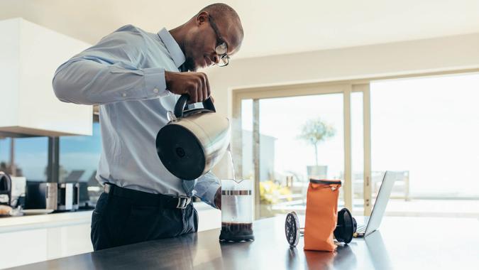 Man pouring hot water in coffee maker.