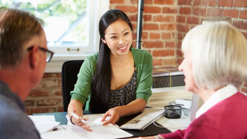 young female accountant helping out retired seniors