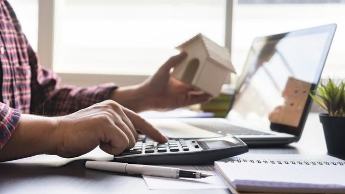 Businessman bookkeeper or financial inspector hands making report, calculating or checking balance on calculator.