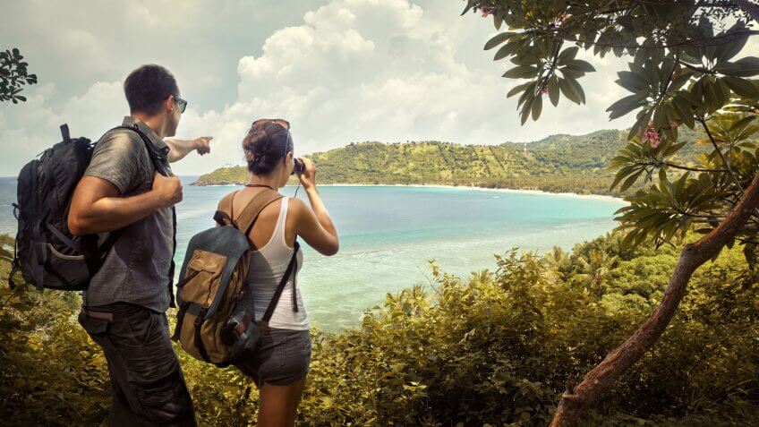 Tourist couple with backpacks enjoying views coast island Lombok.