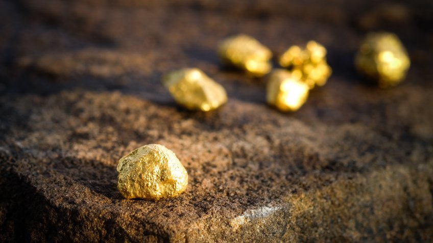The pure gold ore found in the mine on a stone floor.