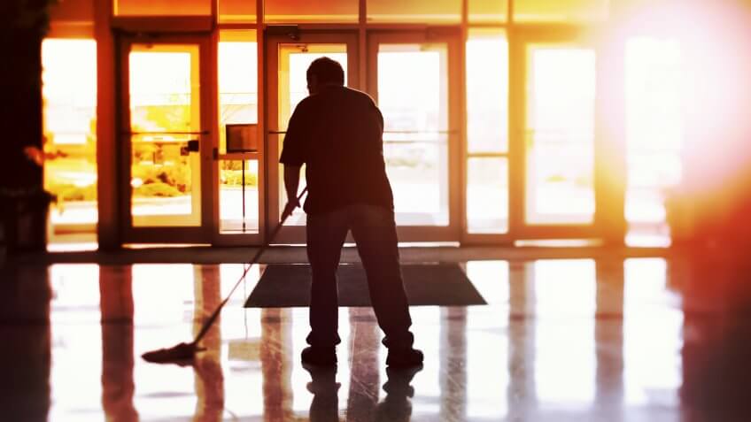 Janitor mopping an office floor, shallow focus, tilt shift image.
