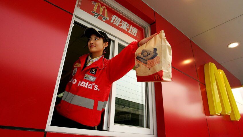 BEIJING - JANUARY 19: A McDonald's employee hands out food as she waits on customers at their new drive-thru facility on January 19, 2007 in Beijing, China.
