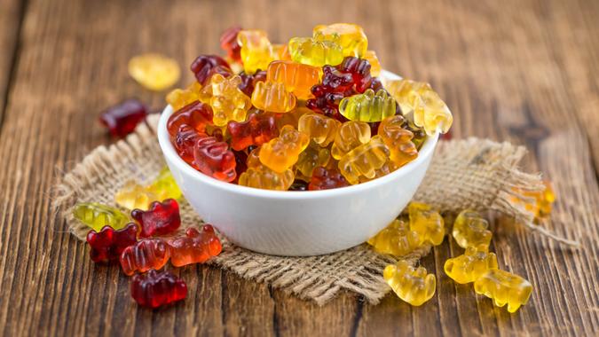 Bowl with Gummy Candy (selective focus) on wooden background.