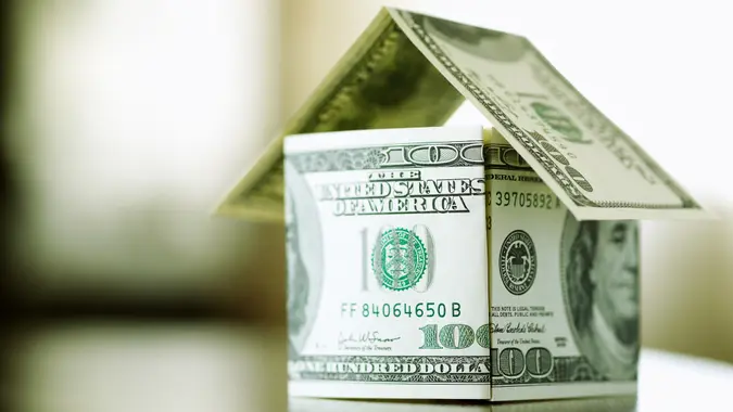 a house made from bills of 100 dollars, dof f/x, selective focus.