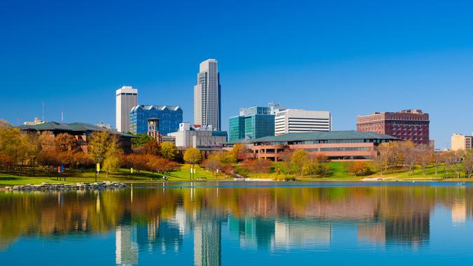 Omaha downtown skyline during Autumn, with a lake at the Heartland of America Park in the foreground.
