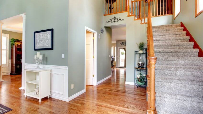 Aqua wall hallway with hardwood floor and staircase.