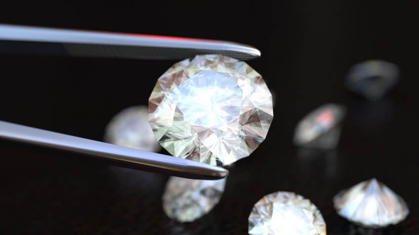 Tweezers holding a white perfect diamond