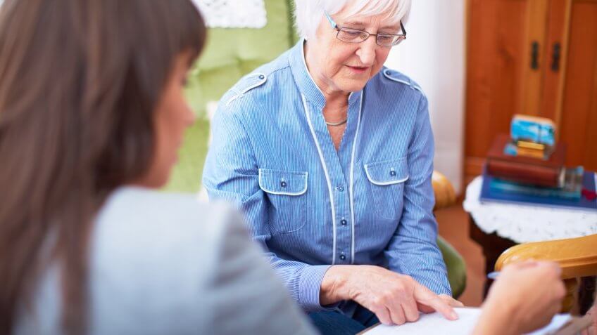 Woman explaining document to senior woman.