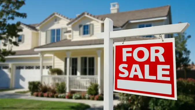 Home For Sale Real Estate Sign in Front of New House.