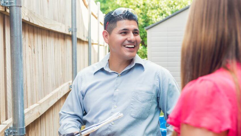Mid adult Hispanic man is repairman or insurance agent.