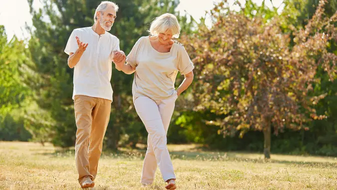 Couple in love holding hands on a walk in the park in summer.