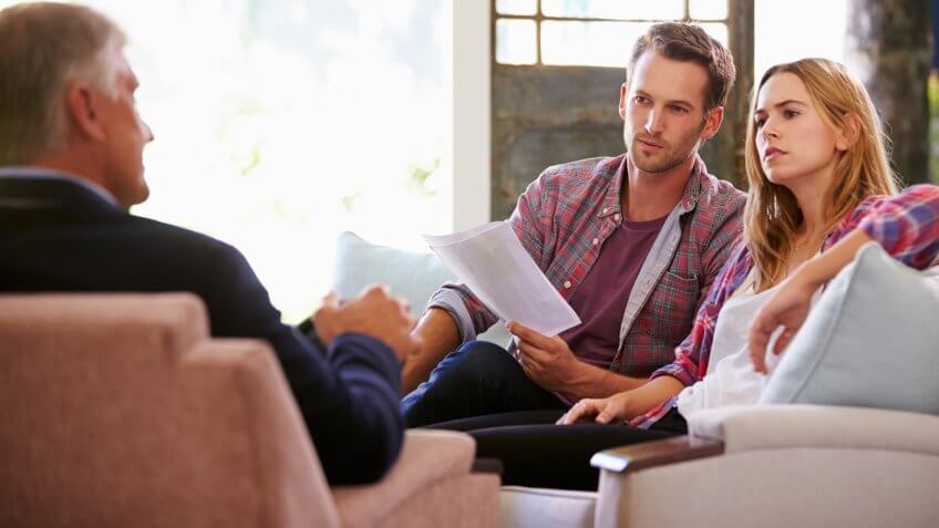 Couple At Home Meeting With Financial Advisor.