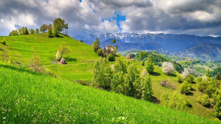 Spring alpine landscape with green fields, Magura village, Transylvania, Romania, Europe.