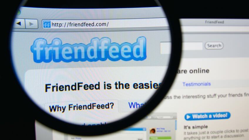 LISBON, PORTUGAL - FEBRUARY 19, 2014: Photo of FriendFeed homepage on a monitor screen through a magnifying glass.