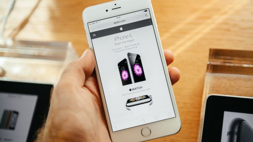 PARIS, FRANCE - SEPTEMBER 20, 2014: Hand holding an Apple iPhone 6 Plus displaying the new Apple homepage with the new iPhone and Apple watch during the sales launch of the latest Apple smartphones.