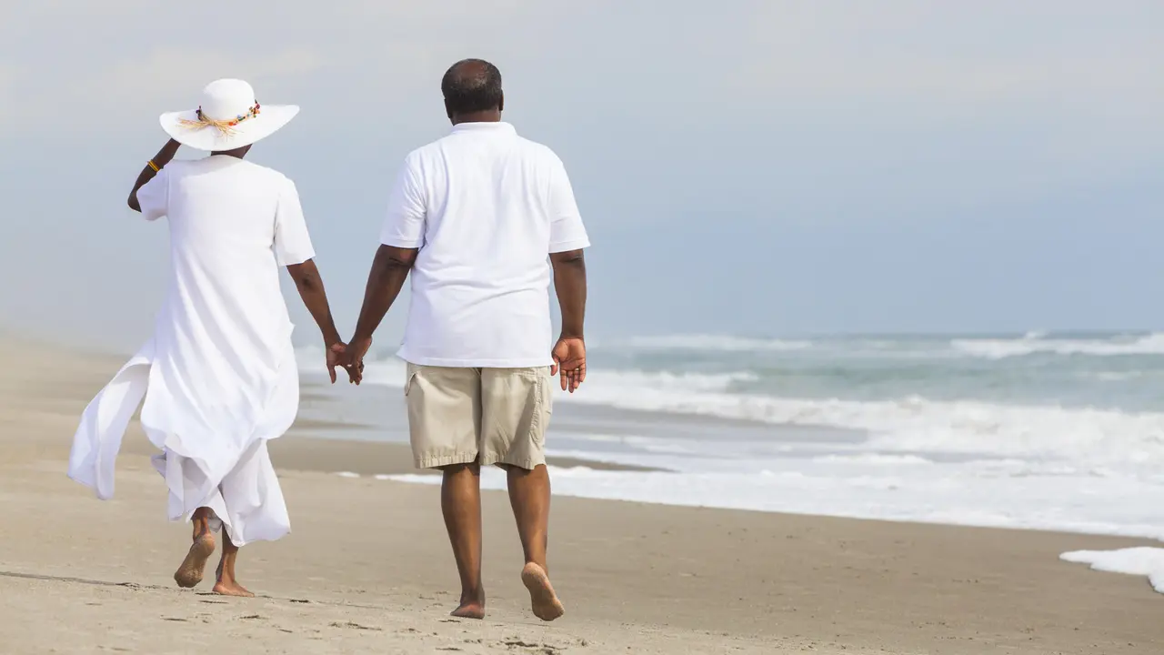 couple walking holding hands on a deserted tropical beach