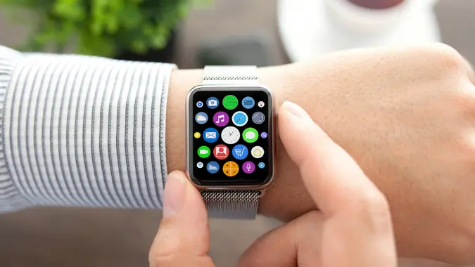 Man hands and smart touch watch with home screen icons apps.