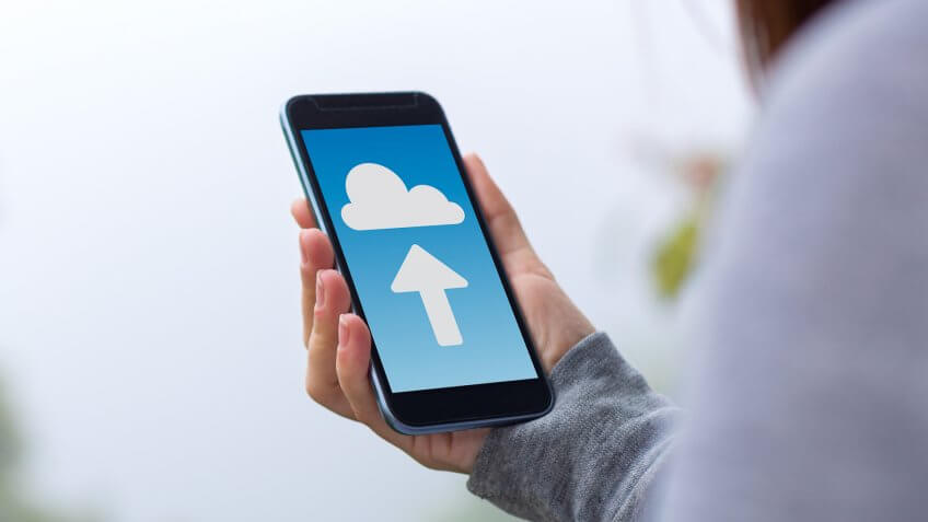 Young woman uploading to the cloud on smartphone.