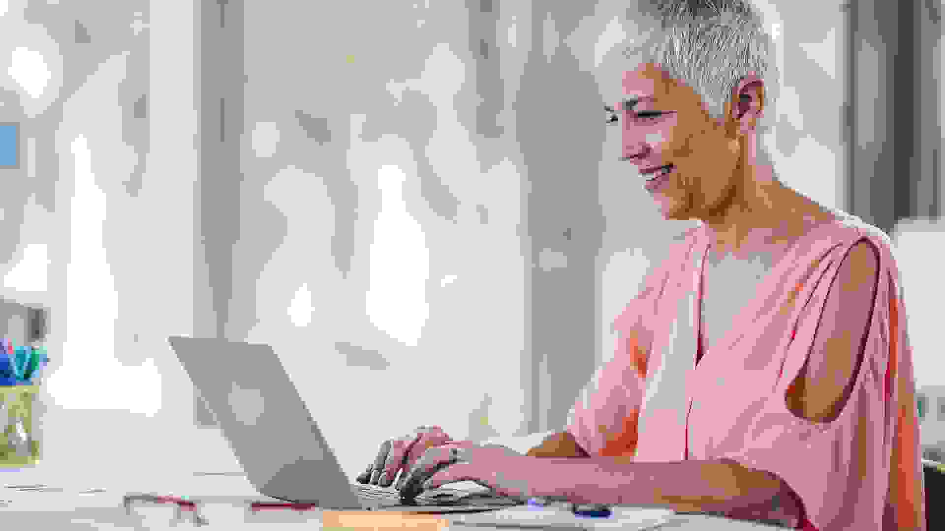 Happy senior businesswoman working on her laptop in the office.