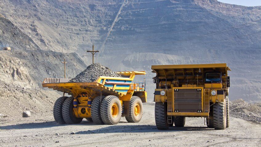 tractors collecting gravel in a mining valley