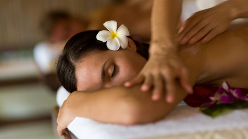 A young woman having massage in tropical spa.