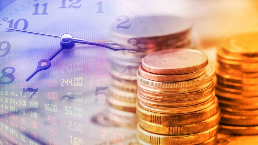 Closeup view : Stack of coins and clock hands.