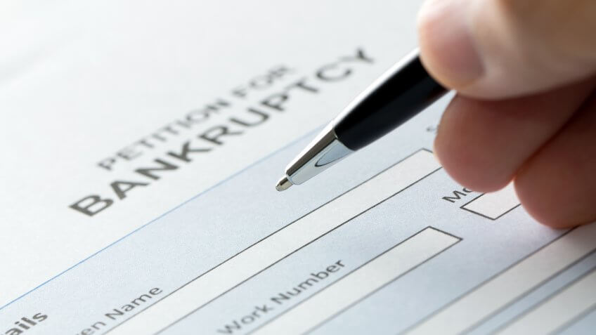 Close up of a person filling petition of bankruptcy form.